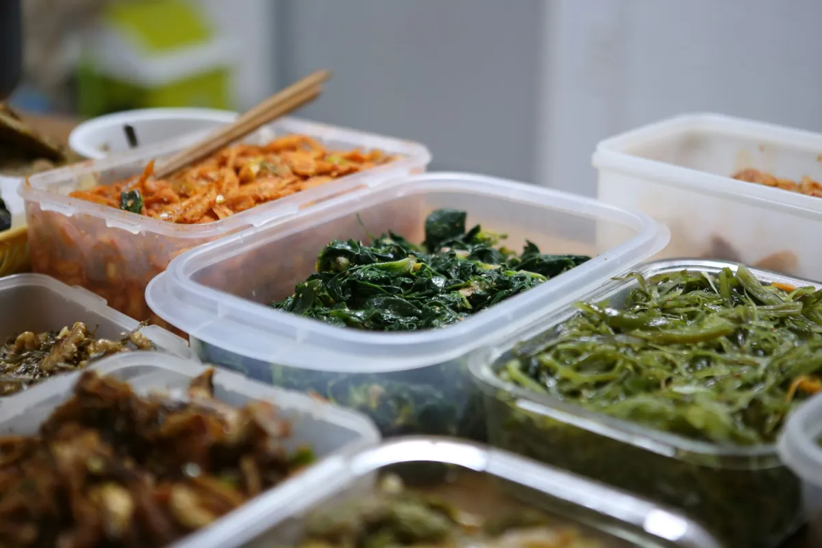 Meal prep containers filled with prepared vegetables and proteins